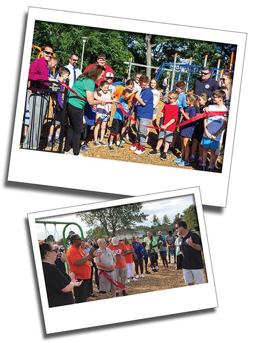 A Ribbon Cutting at a playground in Duncan Park with Park District employees holding the ribbon while a group of children cut it.